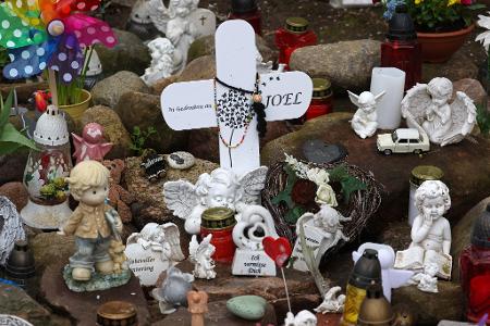 Kreuze, Figuren, Kerzen und Blumen stehen an der Stelle, wo der sechsjährige getötete Joel gefunden wurde. Der Prozess wegen Totschlags geht weiter.