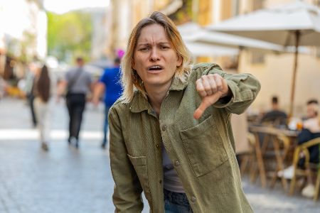 verärgerte Frau senkt den Daumen verärgerte Frau senkt den Daumen