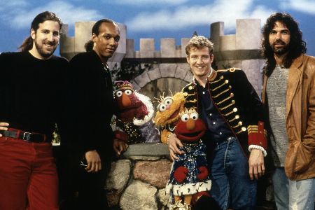 Vier Männer mit Puppen der Sesamstraße.