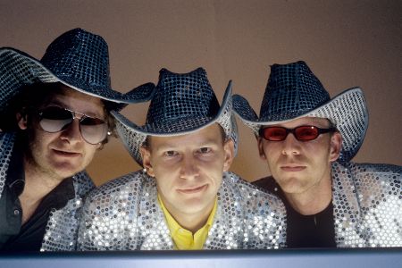 Drei Männer mit silbernen Jackets und silbernen Cowboyhüten.