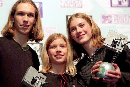Drei Kinder mit Preisen in der Hand lachen in die Kamera