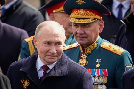 Der russische Präsident Wladimir Putin (l) und der russische Verteidigungsminister Sergej Schoigu (r) verlassen den Roten Platz nach der Militärparade zum Tag des Sieges.