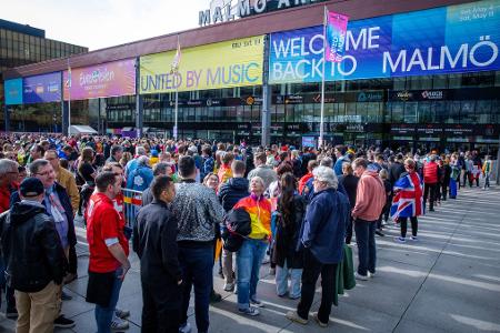 Musikfans stehen vor Beginn des Finales des Eurovision Song Contest 2024 vor der Malmö Arena.