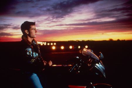 Mann auf Motorrad in Seitansicht vor einem Sonnenuntergang