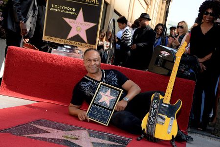 Schwarzer Mann liegt mit einem Bilderrahmen mit Auszeichnung neben seinem Hollywood-Stern auf dem Walk of Fame.