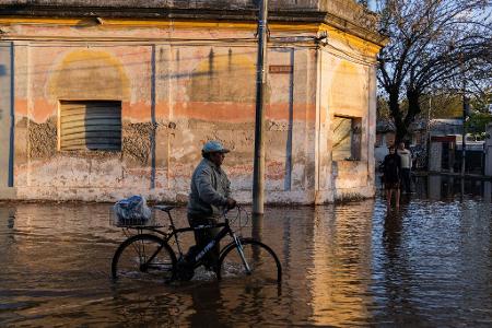 Nicht nur Brasilien hat mit heftigen Regenfällen und Hochwasser zu kämpfen - auch das Nachbarland Uruguay ist betroffen. Dieser Mann watet durch die überfluteten Straßen in Paysandú im Westen des Landes.