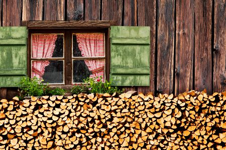 Unter dem Fenster eines Hofes ist ein Holzstapel zu sehen