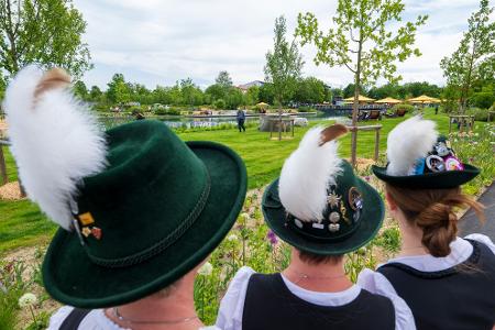 Wiesen, Wasser, Wildnis auf fast 14 Hektar Fläche: Besucherinnen in Tracht werfen einen Blick auf das Gelände der frisch eröffneten Bayerischen Landesgartenschau 2024 in Kirchheim.