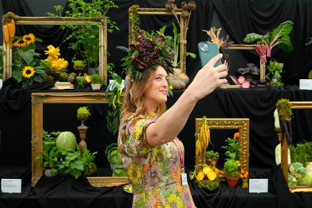 Die jährliche Gartenmesse Chelsea Flower Show in London zieht viele Besucher an. So wie diese Frau mit passender Kopfbedeckung.