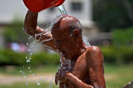 Abkühlung über Kopf: In einem Park pakistanischen Karachi begießt sich ein Mann mit Wasser. Die dortigen Behörden warnten vor Temperaturen bis zu 50 Grad, schlossen Schulen und forderten die Anwohner auf, in ihren Häusern zu bleiben.