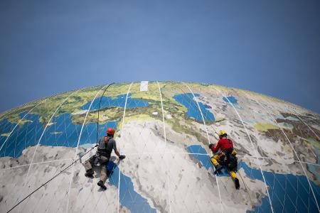 Weltweite Suche: Kletterer warten den Weltballon des Air Service Berlin nahe des Checkpoint Charlie. Mit dem Ballon können Passagiere in die Höhe steigen und auf Berlin herabblicken.