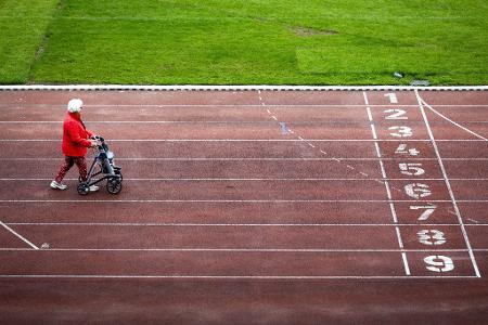 Unterwegs auf zwei Beinen und vier Rändern: Eine Teilnehmerin des niederländischen Rollatorlaufs nähert sich der Zielgeraden. Die Veranstaltung im Olympiastadion Amsterdam soll ein Zeichen für das körperliche und geistige Wohl älterer Menschen setzen.