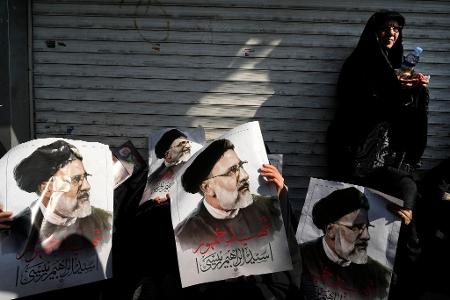Trauernde in Teheran mit Plakaten des verstorbenen iranischen Präsidenten Ebrahim Raisi. Raisi und seine Begleiter sind am Sonntag bei einem Hubschrauberabsturz ums Leben gekommen.