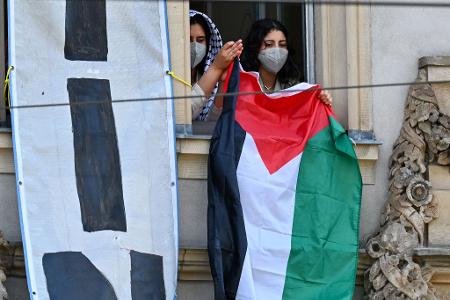 Pro-Palästinensische Demonstranten halten aus einem Fenster des Institutes für Sozialwissenschaften der Berliner Humboldt-Universität eine palästinensische Flagge. Zur Unterstützung der Palästinenser im Gazastreifen und aus Protest gegen Israel haben sie Räume der Uni besetzt.