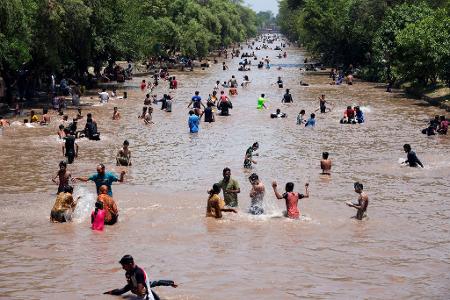 Badespaß: Menschen kühlen sich bei heißem Wetter in einem Kanal in der pakistanischen Megacity Lahore ab. In vielen Städten des Landes herrscht derzeit eine Hitzewelle.