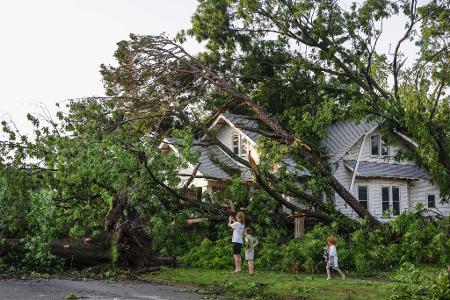 Eine Familie sieht sich die Schäden am Haus ihres Nachbarn in Oklahoma an: Starke Stürme hinterließen in mehreren US-Bundesstaaten eine Spur der Verwüstung.