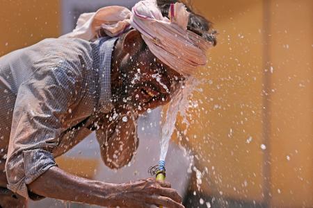 Ein Mann spritzt sich im indischen Lucknow Wasser ins Gesicht, um sich angesichts der Hitze ein bisschen Abkühlung zu verschaffen.
