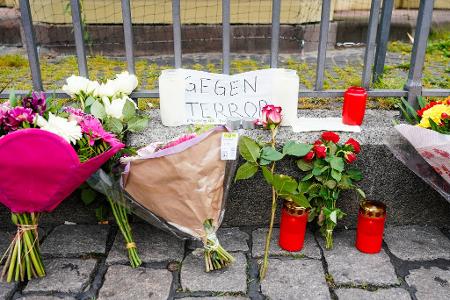 Einen Tag nach dem Messerangriff auf Teilnehmer einer islamkritischen Kundgebung auf dem Mannheimer Marktplatz, haben Menschen Kerzen, Blumen und ein Blatt Papier mit der Aufschrift „Gegen Terror“ am Tatort niedergelegt.