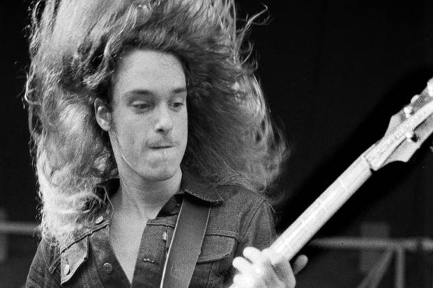 Mann mit langen Haaren spielt Gitarre