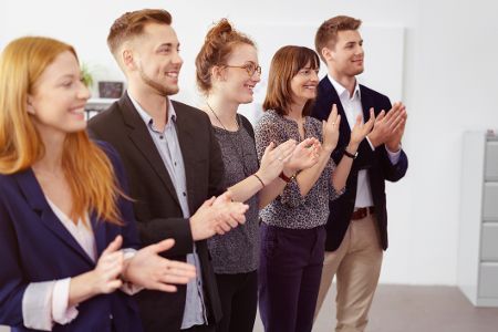 Menschen stehen in einer Reihe und applaudieren