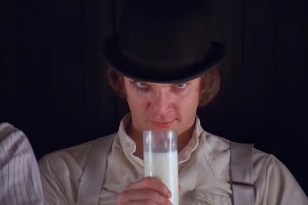 Mann mit Zylinder und Milchglas in der Hand schaut in die Kamera