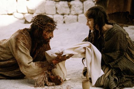 Jesus mit Dornenkranz auf dem Kopf liegt auf dem Boden und bekommt von einer Frau ein Tuch gereicht