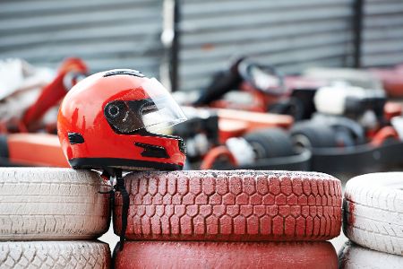 Motorsporthelm liegt auf Reifenstapel