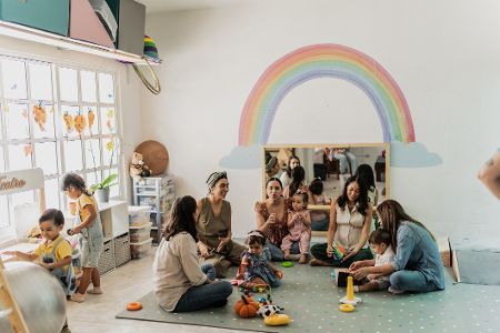 Eltern mit ihren kleinen Kindern in einem Kindergarten Eltern mit ihren kleinen Kindern in einem Kindergarten