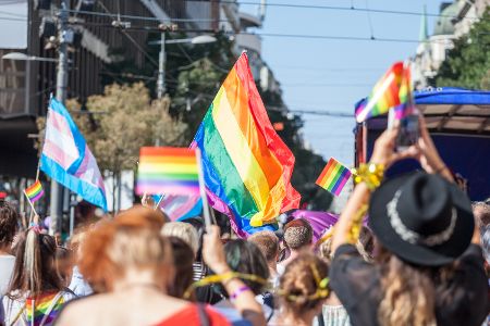 Pride-Parade mit bunten Regenbogenfahnen und vielen Menschen
