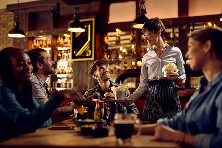 Kellner bewirtet Tisch im Restaurant