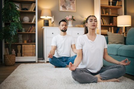paar macht yoga im wohnzimmer