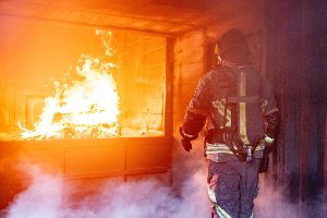 Ein Proband mit einem Prototyp einer intelligenten Feuerwehrjacke in der Brandsimulationsanlage