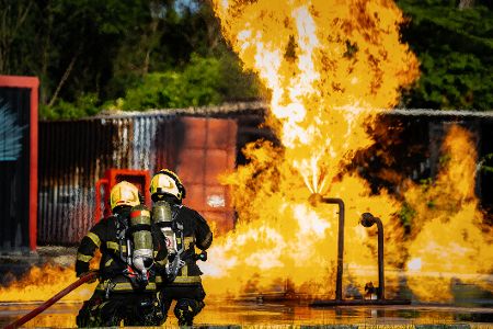 zwei feuerwehrleute vor explosion