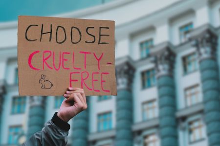 Schild gegen Grausamkeiten gegen Tiere wird hochgehalten