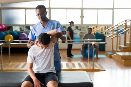 Physiotherapeut betreut Jungen in Einrichtung.