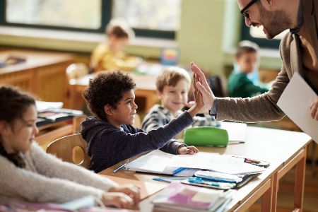 Lehrer gibt Schüler in der ersten Reihe High Five