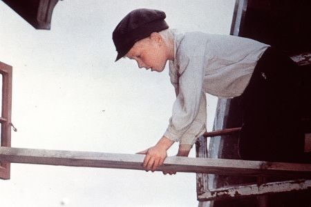 Kleiner Junge krabbelt über ein Brett
