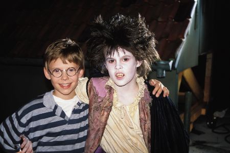 Junge steht neben einem anderen Jungen, der als Vampir verkleidet ist