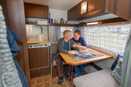 Camping macht Spaß! Auch im Oldtimer haben Andrea und Christian bei unserer Fotoproduktion sichtlich viel Freude. Der vor knapp 50 Jahren gebaute Caravan bietet mit seinem klassischen Stil das perfekte Ambiente.
