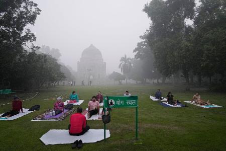 Menschen machen trotz extremer Luftverschmutzung Yoga in einem Park in Neu-Delhi. Menschen machen trotz extremer Luftverschmutzung Yoga in einem Park in Neu-Delhi.