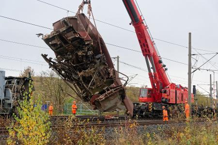 Ein schwerer Kran hob einen ersten Güterwaggon von den Gleisen und stellte ihn neben den Schienen ab. Ein schwerer Kran hob einen ersten Güterwaggon von den Gleisen und stellte ihn neben den Schienen ab.
