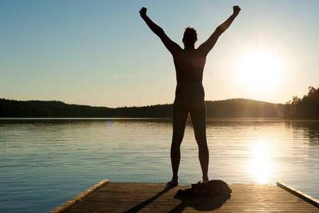 A man stretches his arms on a jetty A man stretches his arms on a jetty