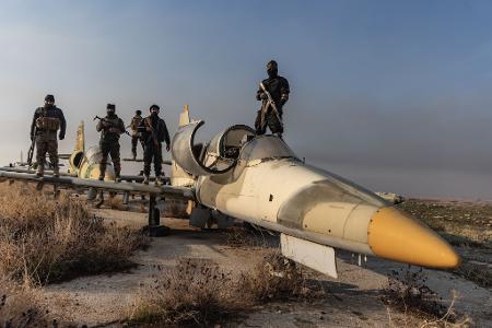 Mitglieder der bewaffneten Opposition zeigen sich auf einem Kampfjet. Das Foto von Anas Alkharboutli entstand, nachdem die Rebellen die Kontrolle über den Militärflughafen Nayrab in der Stadt Aleppo übernommen haben. 