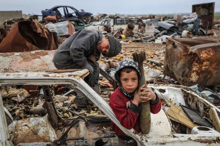 Das Foto des dpa-Fotografen Anas Alkharboutli zeigt ein Kind mit einer nicht explodierten Mörsergranate.