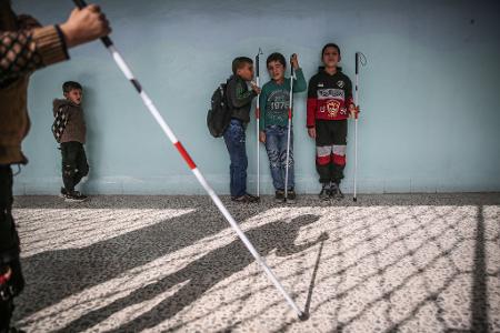 Das Foto des dpa-Fotografen Anas Alkharboutli zeigt blinde Schülerinnen und Schüler vor ihrem Klassenzimmer in Idlib.
