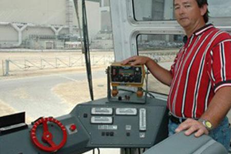 Bob Myers, a crawler systems engineer with United Space Alliance, stands beside the driver's console inside a Crawler-Transporter cab. Credit: NASA/KSC