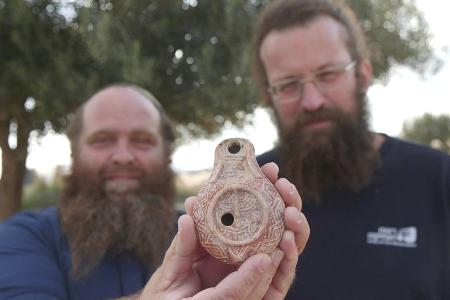 Stolz präsentieren die Archäologen ihren Fund.