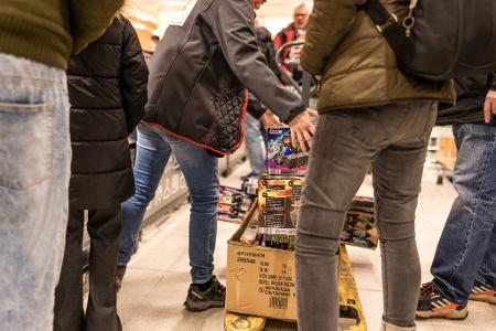 Während Supermarkt-Mitarbeiter noch die Regale einräumen, warten die ersten Kunden schon aufs Feuerwerk. 