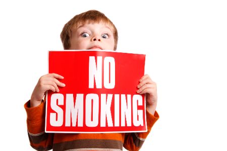 Kind hält Schild mit No-Smoking-Aufdruck