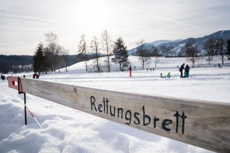 Eisflächen sind nur ab einer ausreichenden Dicke sicher begehbar: Bricht jemand ein, sollten Helfende vom Ufer aus Rettungshilfen wie Bretter, Leitern oder Äste nutzen, um die gefährdete Person an Land zu bringen. Eisflächen sind nur ab einer ausreichenden Dicke sicher begehbar: Bricht jemand ein, sollten Helfende vom Ufer aus Rettungshilfen wie Bretter, Leitern oder Äste nutzen, um die gefährdete Person an Land zu bringen.